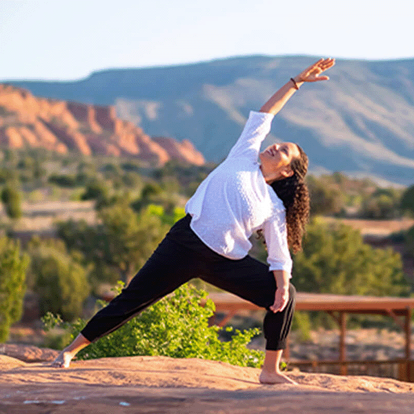 Woman does yoga in the mountains