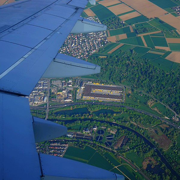 aerial shot of semi-urban city from plane with wing in foreground